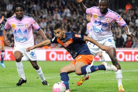 Montpellier's midfielder Younes Belhanda (C) vies with Evian 's defender Cedric Mongongu (R) and midfielder Eric Tie Bi (L) during the French L1 football match Montpellier vs Evian, on May 1, 2012 at the Mosson stadium in Montpellier, southern France.     AFP PHOTO / PASCAL GUYOT        (Photo credit should read PASCAL GUYOT/AFP/GettyImages)
