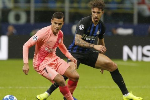 Barcelona's Philippe Coutinho, left, and Inter Milan's Sime Vrsaljko vie for the ball during the Champions League group B soccer match between Inter Milan and Barcelona at the San Siro stadium in Milan, Italy, Tuesday, Nov. 6, 2018. (AP Photo/Antonio Calanni)