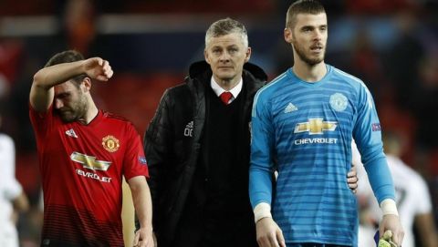 Manchester United caretaker manager Ole Gunnar Solskjaer, center, with Juan Mata, left, and David de Gea leave the field and after defeat in the Champions League round of 16 soccer match between Manchester United and Paris Saint Germain at Old Trafford stadium in Manchester, England, Tuesday, Feb. 12, 2019. (Martin Rickett/PA via AP)