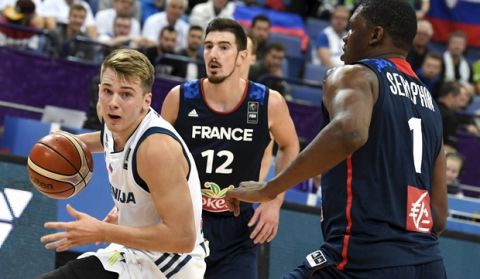 Luka Doncic of Slovenia, left, and Kevin Seraphin, right, and Nando de Colo of France during the basketball European Championships Eurobasket 2017 qualification round match between Slovenia and France in Helsinki, Finland, Wednesday, Sept. 6, 2017. (Jussi Nukari/ Lehtikuva via AP)