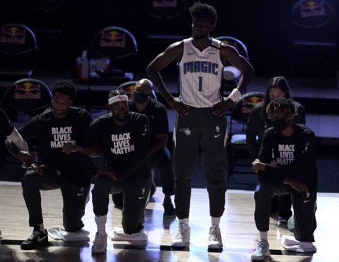 Orlando Magic's Jonathan Isaac (1) stands as others kneel before the start of an NBA basketball game between the Brooklyn Nets and the Orlando Magic Friday, July 31, 2020, in Lake Buena Vista, Fla. (AP Photo/Ashley Landis, Pool)