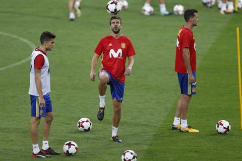 Spain's Gerard Pique, centre, plays with a ball during a training session of the Spanish soccer national team at the Santiago Bernabeu stadium in Madrid, Friday, Sept. 1, 2017.  Spain will play a World Cup Group G qualifying soccer match against Italy on Saturday 2. (AP Photo/Francisco Seco)