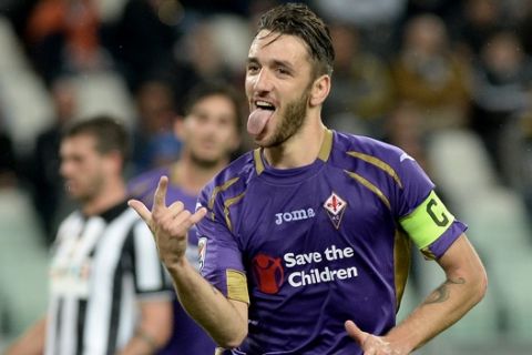 Fiorentina's Gonzalo Rodriguez sticks his tongue out as he celebrates after scoring during a Serie A soccer match between Juventus and Fiorentina  at the Juventus stadium, in Turin, Italy, Wednesday, April 29, 2015. (AP Photo/Massimo Pinca)