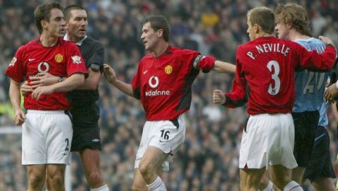 ** FILE ** In this Saturday, Feb. 14, 2004 file photo Manchester United's Roy Keane, center, looks on as Gary Neville, left, is restrained by Referee Jeff Winter after headbutting Manchester City's Steve McManaman,  right, leading to  Neville being sent off during their English FA Cup 5th round game at Old Trafford stadium, Manchester England. (AP Photo/Jon Super, File)