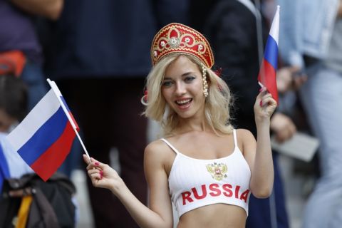 A Russian fan poses for the cameras as she gets ready to cheer on their side as they pose a photograph before the start of the group A match between Russia and Saudi Arabia which opens the 2018 soccer World Cup at the Luzhniki stadium in Moscow, Russia, Thursday, June 14, 2018. (AP Photo/Antonio Calanni)