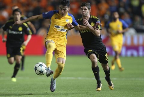 APOEL Nicosia's Praksitelis Vouros, left, and Dortmund's Christian Pulisic challenge for the ball during the Champions League Group H soccer match between APOEL Nicosia and Borussia Dortmund at GSP stadium, in Nicosia, Cyprus, on Tuesday, Oct. 17, 2017. (AP Photo/Petros Karadjias)