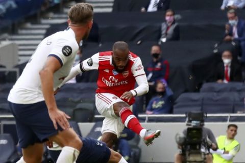 Arsenal's Alexandre Lacazette, center, scores the opening goal during the English Premier League soccer match between Tottenham Hotspur and Arsenal at the Tottenham Hotspur Stadium in London, England, Sunday, July 12, 2020. (Julian Finney/Pool via AP)