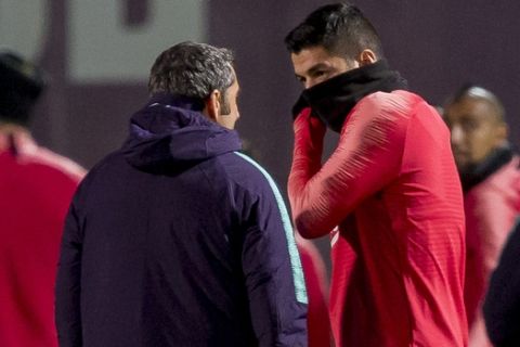 FC Barcelona's Ernesto Valverde, left, talks with Luis Suarez during a training session at the Sports Center FC Barcelona Joan Gamper in Sant Joan Despi, Monday, Dec. 10, 2018. FC Barcelona will play against Tottenham Hotspur in a Champions League group B Champions League soccer match on Tuesday. (AP Photo/Joan Monfort)
