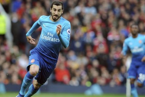 FILE - In this Sunday, April 29, 2018 file photo, Arsenal's Henrikh Mkhitaryan runs with the ball during their English Premier League soccer match against Manchester United at the Old Trafford stadium in Manchester, England. Arsenal will be without Henrikh Mkhitaryan for at least six weeks because of an injury to his right foot, the London club said on Monday, Dec. 24. The Armenia playmaker fractured a metatarsal in Wednesday's 2-0 League Cup quarter-final defeat by neighbor Tottenham and was replaced at half-time. (AP Photo/Rui Vieira, file)