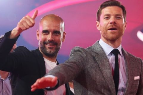 In this May 14, 2016 picture Bayern Munich  head Coach, Pep Guardiola, left,  and soccer player Xabi Alonso  celebrate  during the FC Bayern  Munich  Bundesliga Champions Dinner in Munich, Germany.  ( Lars Baron/Pool Photo via AP)