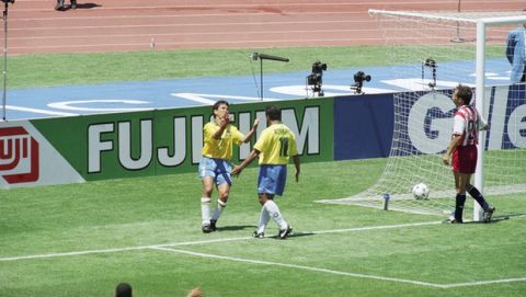 Brazilian forwards Bebeto, far left, and Romario celebrate the winning goal for Brazil scored by Bebeto as United States defender Fernando Clavijo walks past the goalpost with the ball still in the net during the World Cup soccer championship second round match at Stanford Stadium, Stanford, CA., Monday, July 4, 1994. Brazil defeated the U.S. and will advance to the quarterfinals playing Holland at the Dallas, Texas, Cotton Bowl, Saturday, July 9. (AP Photo/Eric Risberg)