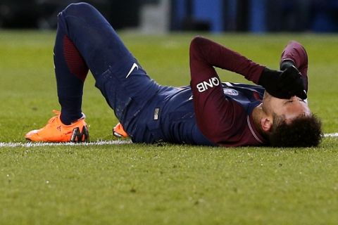 PSG's Neymar lays on the pitch after being fouled during the French League One soccer match between Paris Saint-Germain and Marseille at the Parc des Princes Stadium, in Paris, France, Sunday, Feb. 25, 2018. (AP Photo/Thibault Camus)