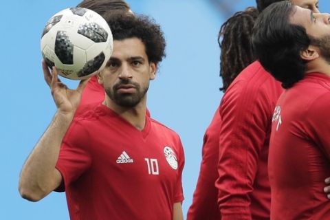 Egypt's Mohamed Salah, left, plays with the ball during Egypt's official training on the eve of the group A match between Russia and Egypt at the 2018 soccer World Cup in the St. Petersburg stadium in St. Petersburg, Russia, Monday, June 18, 2018. (AP Photo/Dmitri Lovetsky)