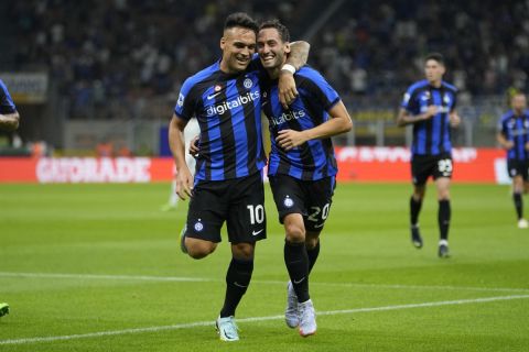 Inter Milan's Hakan Calhanoglu, left, celebrates with his teammate Lautaro Martinez, left, after scoring against Spezia during a Serie A soccer match between Inter Milan and Spezia at the San Siro stadium in Milan, Italy, Saturday, Aug.20, 2022. (AP Photo/Luca Bruno)