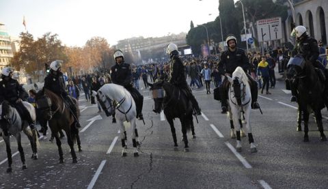 Mounted police officers look around at Boca Juniors supporters they are escorting ahead of the Copa Libertadores Final between River Plate and Boca Juniors in Madrid, Sunday, Dec. 9, 2018. Tens of thousands of Boca and River fans are in the city for the "superclasico" at Santiago Bernabeu Stadium on Sunday. (AP Photo/Emilio Morenatti)