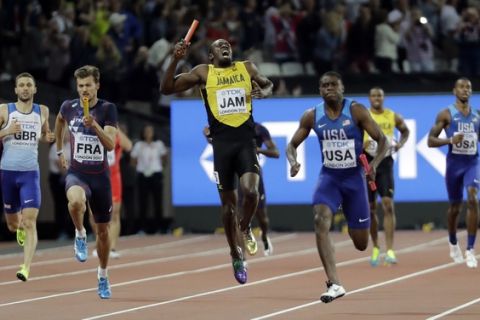 Jamaica's Usain Bolt, center, pulls up injured in the final of the Men's 4x100m relay during the World Athletics Championships in London Saturday, Aug. 12, 2017. At right is United States' Christian Coleman. (AP Photo/David J. Phillip)