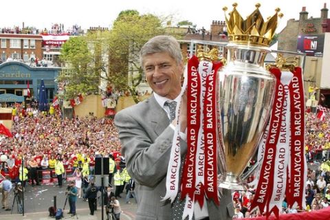 Arsenal manager Arsene Wenger holds up the English Premiership Trophy outside Islington Town Hall in North London, Sunday May 16, 2004, during their victory parade. (AP Photo/Lawrence Lustig, Pool)