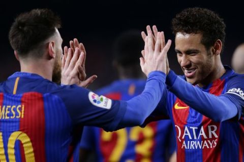 FC Barcelona's Lionel Messi, left, is greeted by team mate Neymar as they celebrate after scoring a goal during the Spanish La Liga soccer match between FC Barcelona and Valencia at the Camp Nou stadium in Barcelona, Spain, Sunday, March 19, 2017. (AP Photo/Manu Fernandez)