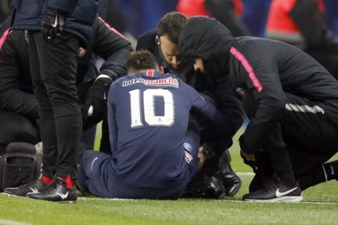 In this photo taken on Wednesday, Jan. 23, 2019, PSG's Neymar receives medical attention on the sidelines during the French Cup soccer match against Strasbourg at the Parc des Princes stadium in Paris. Neymar limped off with a recurrence of a right-foot injury during Paris Saint-Germain's 2-0 French Cup win against Strasbourg on Wednesday, casting doubt whether he will face Manchester United in the first leg of their Champions League last-16 match next month. (AP Photo)