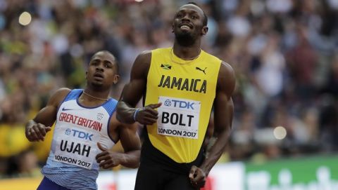 Jamaica's Usain Bolt and Britain's Chijindu Ujah, left, react after finishing a Men's 100 meters semifinal during the World Athletics Championships in London Saturday, Aug. 5, 2017. (AP Photo/Tim Ireland)