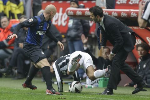 Juventus midfielder Andrea Pirlo challenge for the ball with Inter Milan Argentine midfielder Esteban Cambiasso as Inter Milan coach Andrea Stramaccioni gestures during a Serie A soccer match between Inter Milan and Juventus, at the San Siro stadium in Milan, Italy, Saturday, March 30, 2013. (AP Photo/Luca Bruno)