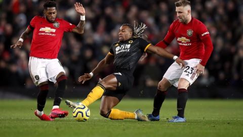 Wolverhampton Wanderers' Adama Traore battles for the ball with Manchester United's Fred, left, and Luke Shaw, right, during the English Premier League soccer match between Manchester United and Wolverhampton Wanderers, at Old Trafford, Manchester, England, Saturday, Feb. 1, 2020. (Martin Rickett/PA via AP)