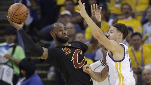 Cleveland Cavaliers forward LeBron James (23) passes as he is guarded by Golden State Warriors guard Klay Thompson during the first half of Game 5 of basketball's NBA Finals in Oakland, Calif., Monday, June 12, 2017. (AP Photo/Marcio Jose Sanchez)