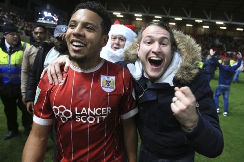 Bristol City's Korey Smith celebrates scoring his side's second goal of the game with fans after the final whistle in the English League Cup Quarter Final soccer match between Bristol City and Manchester United at Ashton Gate, Bristol, England, Wednesday, Dec. 20, 2017. Bristol City defeated Manchester United 2-1. (Nick Potts/PA via AP)
