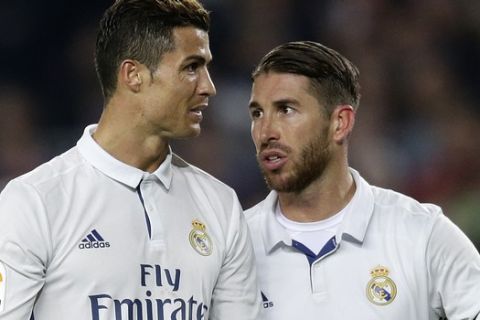 Real Madrid's Sergio Ramos, right, talks with teammate Cristiano Ronaldo during the Spanish La Liga soccer match between FC Barcelona and Real Madrid at the Camp Nou in Barcelona, Spain, Saturday, Dec. 3, 2016. (AP Photo/Manu Fernandez)