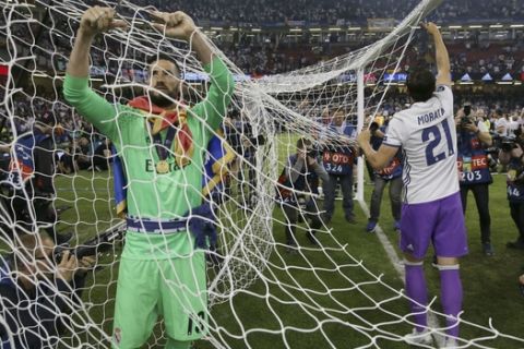 Real Madrid's goalkeeper Kiko Casilla, left, and Real Madrid's Alvaro Morata cuts the net after the Champions League final soccer match between Juventus and Real Madrid at the Millennium Stadium in Cardiff, Wales, Saturday June 3, 2017. (AP Photo/Tim Ireland)
