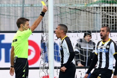 Referee Davide Massa shows a yellow card to Udinese's Allan, during the Serie A soccer match between Udinese and Lazio at the Friuli Stadium in Udine, Italy, Sunday, Feb. 15, 2015. (AP Photo/Paolo Giovannini)