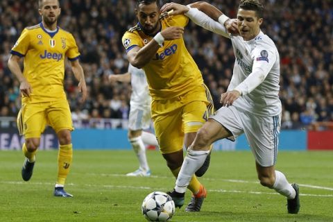 Real Madrid's Cristiano Ronaldo fights for the ball against Juventus' Medhi Benatia during a Champions League quarter final second leg soccer match between Real Madrid and Juventus at the Santiago Bernabeu stadium in Madrid, Wednesday, April 11, 2018. (AP Photo/Francisco Seco)