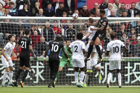 Newcastle United's Jamaal Lascelles, top right, scores against Swansea City during the English Premier League soccer match at the Liberty Stadium, Swansea, Wales, Sunday Sept. 10, 2017. (Nick Potts/PA via AP)