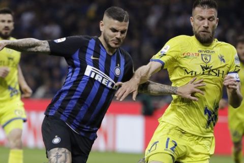 Inter Milan's Mauro Icardi, left, challenges for the ball with Chievo's Bostjan Cesar during a Serie A soccer match between Inter Milan and Chievo, at the San Siro stadium in Milan, Italy, Monday, May 13, 2019. (AP Photo/Luca Bruno)