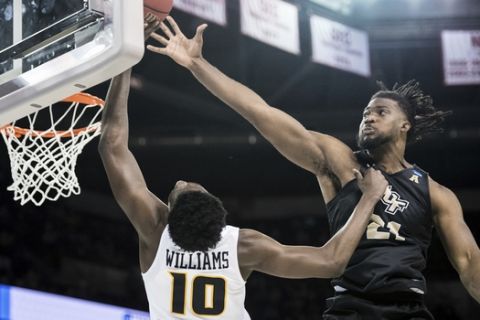 Central Florida forward Chad Brown (21) blocks a shot by VCU guard Vince Williams (10) during the second half of a first-round game in the NCAA men's college basketball tournament Friday, March 22, 2019, in Columbia, S.C. Central Florida won 73-58. (AP Photo/Sean Rayford)