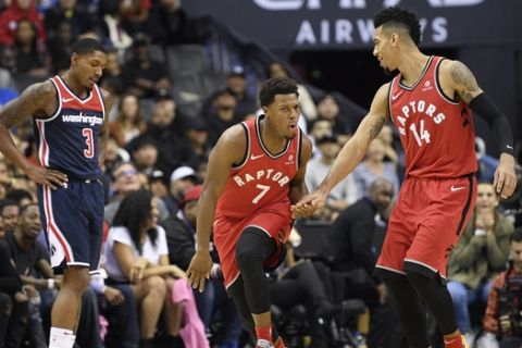 Toronto Raptors guard Kyle Lowry (7) reacts with guard Danny Green (14) after he made a three-point basket during the second half of an NBA basketball game as Washington Wizards guard Bradley Beal stands at left, Saturday, Oct. 20, 2018, in Washington. The Raptors won 117-113. (AP Photo/Nick Wass)
