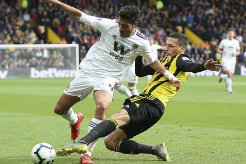 Wolverhampton Wanderers' Raul Jimenez, left, and Watford's Jose Holebas  battle for the ball during their English Premier League soccer match at Vicarage Road, Watford, England, Saturday, April 27, 2019. (Nigel French/PA via AP)