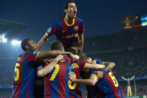 FC Barcelona's Sergio Busquets, top, celebrates with fellow team members after Andres Iniesta, partially visible at center foreground, scored a goal during their quarterfinal first leg Champions League soccer match against Shakhtar Donetsk at the Camp Nou stadium in Barcelona, Spain, Wednesday, April 6, 2011. (AP Photo/Siu Wu)