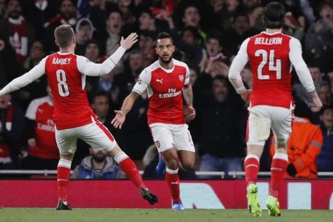 Arsenal's Theo Walcott, center, celebrates with his teammates Aaron Ramsey, left and Hector Bellerinafter scoring the opening goal during the Champions League round of 16 second leg soccer match between Arsenal and Bayern Munich at the Emirates Stadium in London, Tuesday, March 7, 2017. (AP Photo/Kirsty Wigglesworth)
