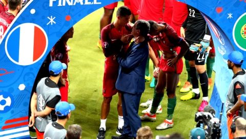 Portugal coach Fernando Santos speaks with Cristiano Ronaldo, as they celebrate their victory at the Euro 2016 final soccer match between Portugal and France at the Stade de France in Saint-Denis, north of Paris, Sunday, July 10, 2016. (AP Photo/Thibault Camus)