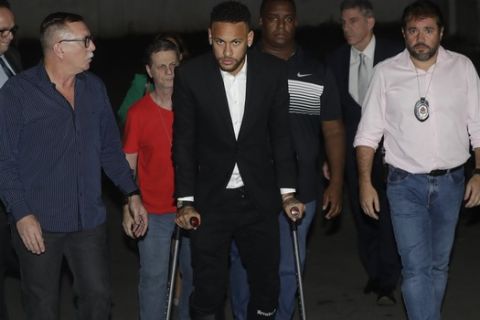 Using crutches because of an injured right ankle, Brazil's soccer player Neymar leaves a police station where he answered questions about rape allegations against him in Sao Paulo, Brazil, Thursday, June 13, 2019. Neymar spent about five hours at the police station Thursday to undergo questioning about rape allegations against him, one of the final steps in the investigation. Prosecutor Flavia Merlini told journalists that the player denies the accusations and responded (to questions) in a satisfactory way. (AP Photo/Andre Penner)