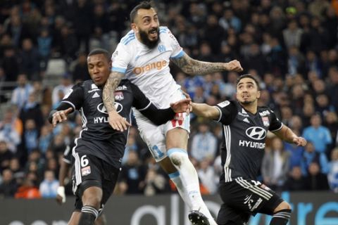 Marseille's Konstantinos Mitroglou, center, challenges for the ball with Lyon's Marcelo, left, and Rafael Da Silva during the League One soccer match between Marseille and Lyon at the Velodrome stadium, in marseille, southern France , Sunday, March 18, 2018. (AP Photo/Claude Paris)