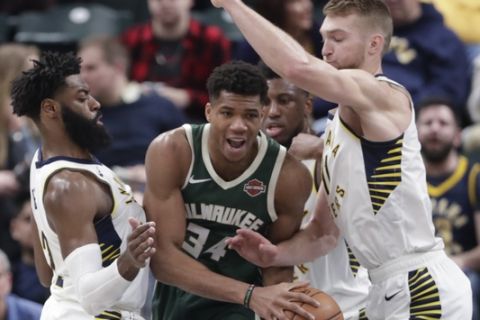 Indiana Pacers guard Tyreke Evans (12) and forward Domantas Sabonis (11) trap Milwaukee Bucks forward Giannis Antetokounmpo (34) during the first half of an NBA basketball game in Indianapolis, Wednesday, Dec. 12, 2018. (AP Photo/Michael Conroy)