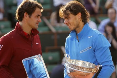 Spain's Rafael Nadal, right, and  Switzerland's Roger Federer pose with their trophies after the men's final match for the French Open tennis tournament at the Roland Garros stadium, Sunday, June 5, 2011, in Paris.  (AP Photo/Lionel Cironneau)