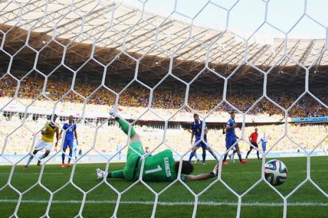 BELO HORIZONTE, BRAZIL - JUNE 14:  Orestis Karnezis of Greece dives in vain as James Rodriguez of Colombia (obscured) scores his teams third goal during the 2014 FIFA World Cup Brazil Group C match between Colombia and Greece at Estadio Mineirao on June 14, 2014 in Belo Horizonte, Brazil.  (Photo by Paul Gilham/Getty Images)