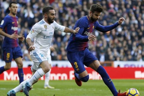 Barcelona's Gerard Pique, right, vies for the ball with Real Madrid's Daniel Carvajal during the Spanish La Liga soccer match between Real Madrid and Barcelona at the Santiago Bernabeu stadium in Madrid, Spain, Saturday, Dec. 23, 2017. (AP Photo/Francisco Seco)