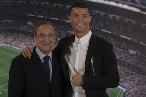Real Madrid's Cristiano Ronaldo, right, poses with the club's President Florentino Perez after signing a new contract at the Santiago Bernabeu stadium in Madrid, Spain, Monday, Nov. 7, 2016. Real Madrid have extend Ronaldo's contract until June 2021, when the three-time world player of the year will be 36. Financial details were not released, although the star forward is expected to remain the team's top-paid player. (AP Photo/Paul White)