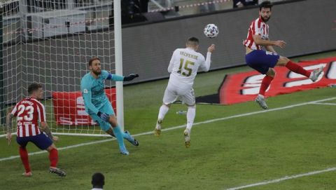 Real Madrid's Federico Valverde heads to clear the ball in front of Real Madrid's goalkeeper Thibaut Courtois during the Spanish Super Cup Final soccer match between Real Madrid and Atletico Madrid at King Abdullah stadium in Jiddah, Saudi Arabia, Sunday, Jan. 12, 2020. (AP Photo/Amr Nabil)