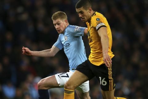 Manchester City's Kevin De Bruyne, left, fights for the ball with Wolverhampton Wanderers' Conor Coady during the English Premier League soccer match between Manchester City and Wolverhampton Wanderers at the Etihad Stadium in Manchester, England, Monday, Jan. 14, 2019. (AP Photo/Dave Thompson)