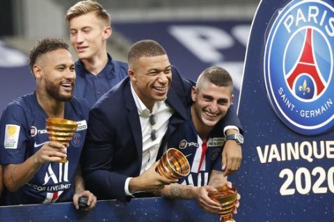 PSG's Kylian Mbappe, centre, who did not play due to an injury, celebrates with his teammate Neymar, left, and other teammates, after winning the French League Cup, following the soccer final match against Lyon at Stade de France stadium, in Saint Denis, north of Paris, Friday, July 31, 2020. (AP Photo/Francois Mori)